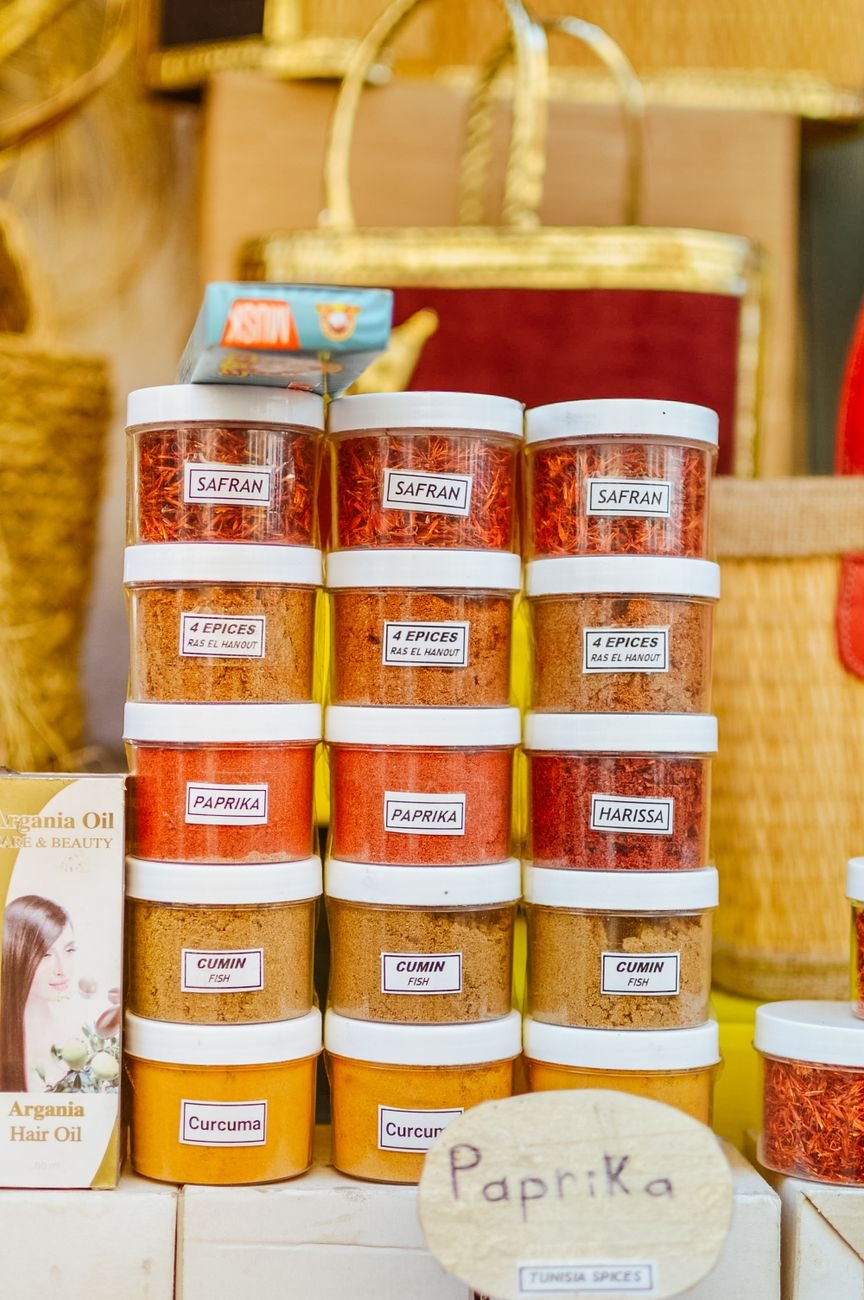 Colorful jars of various spices neatly displayed at a market stall.
